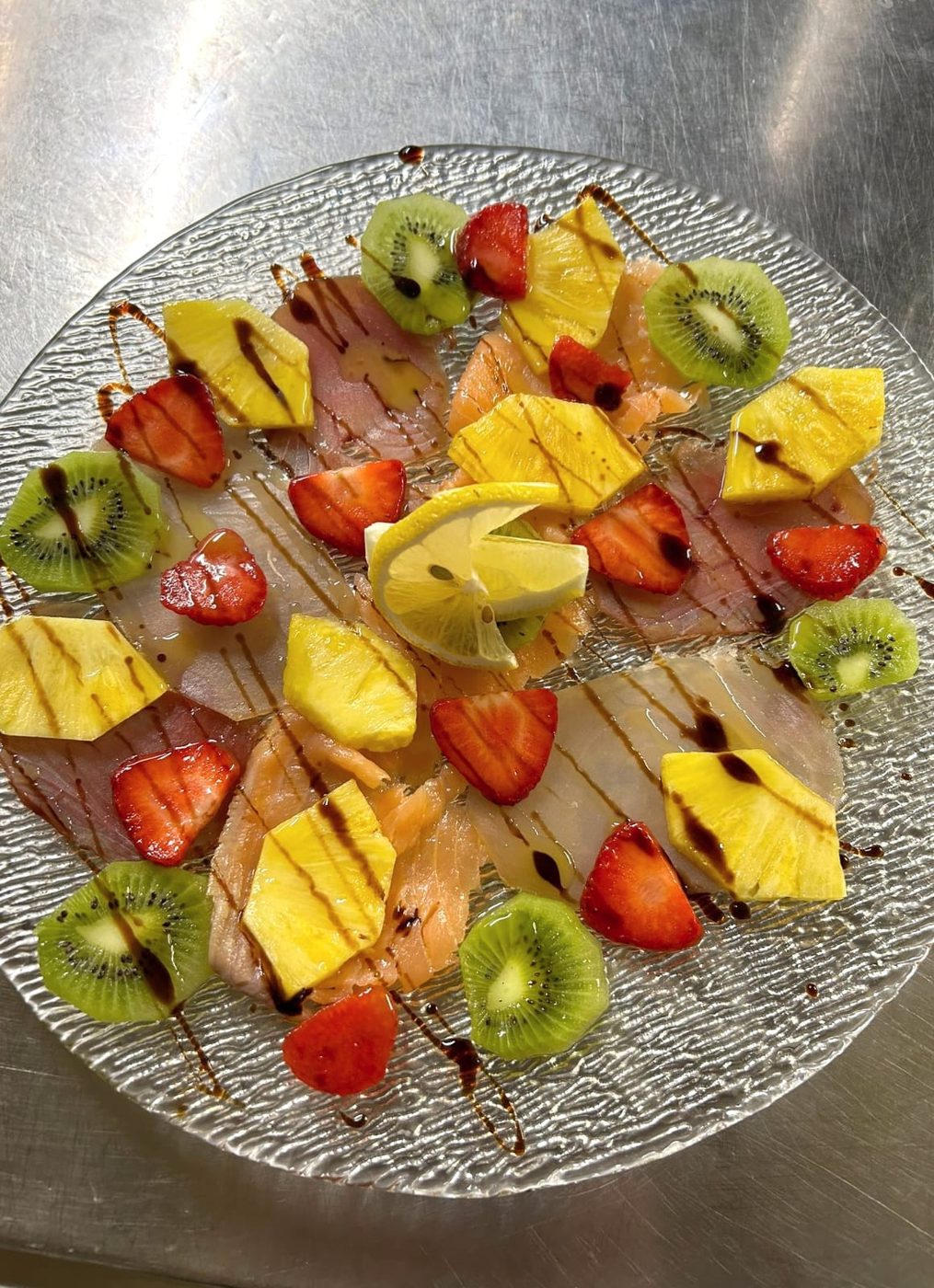 Carpaccio di pesce con frutta e riduzione